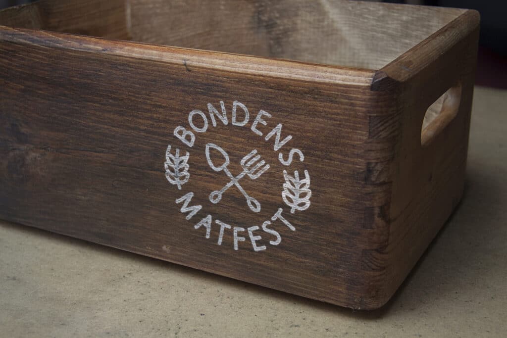 Bondens Matfest logo på kasse i tre